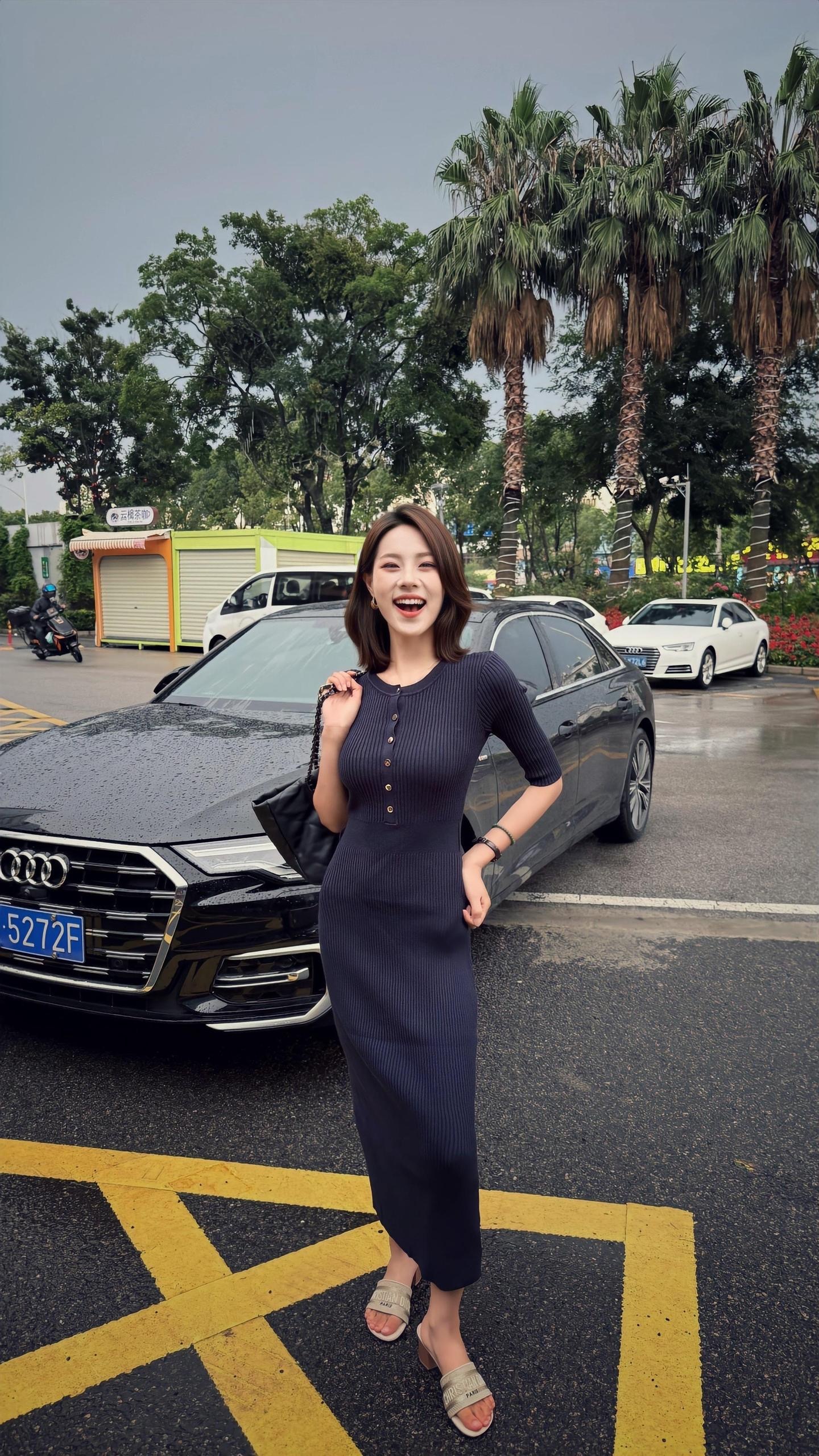 검은색 승용차 옆에서 웃으며 서 있어