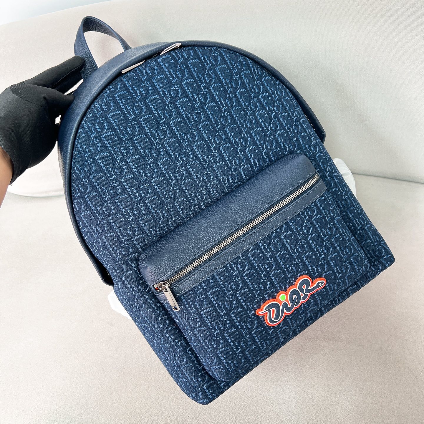 AND KAWS RIDER 2.0 ZIPPED BACKPACK NAVY BLUE GRAINED CALFSKIN AND OBLIQUE JACQUARD
